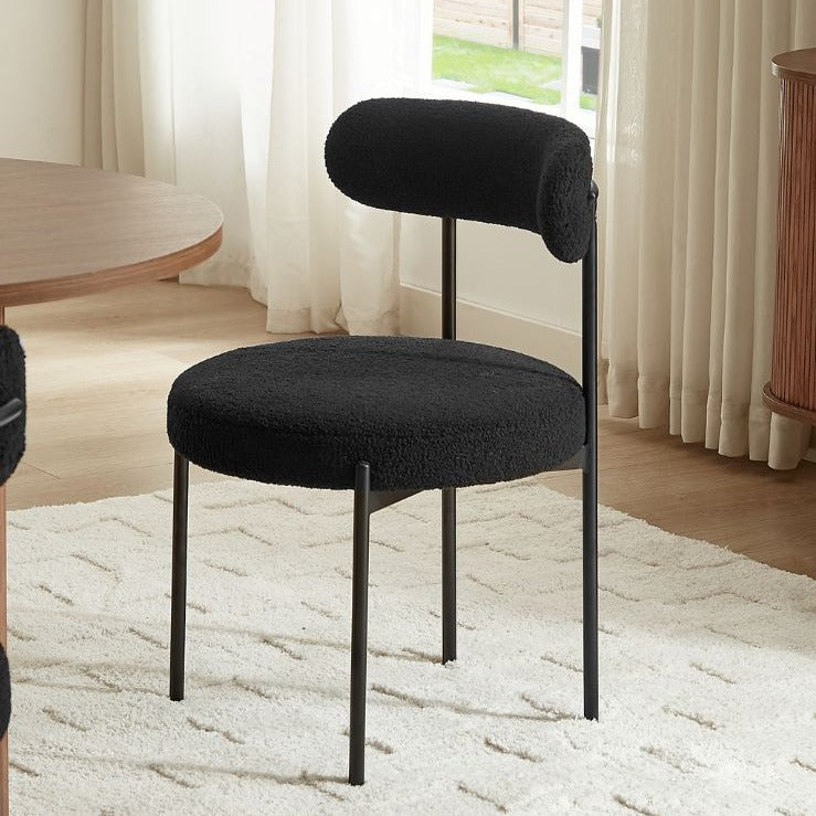 Gros plan sur le tissu bouclette doux et texturé de la chaise, aspect moelleux et confortable.
