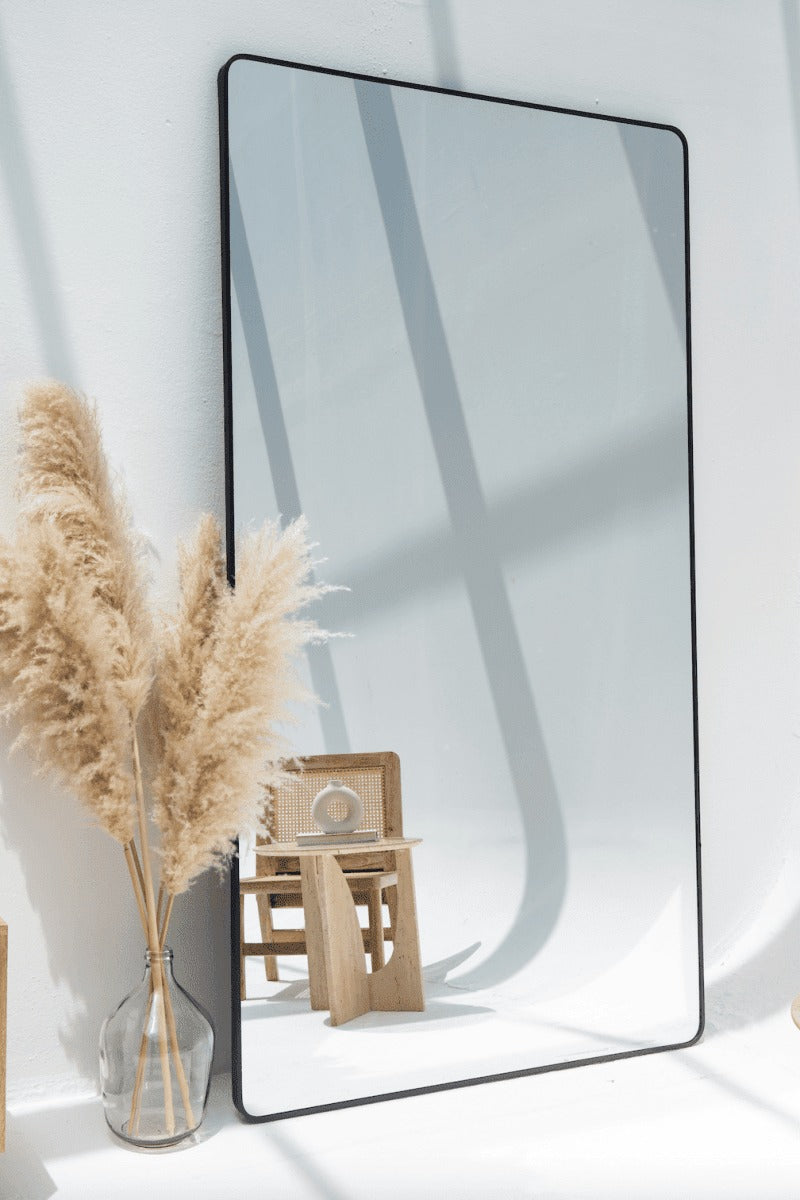 Miroir mural élégant avec cadre noir mat – décoration moderne pour salon ou entrée.