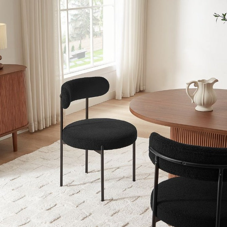 Détail du cadre en métal noir mat et des pieds solides de la chaise en bouclette, style industriel chic.