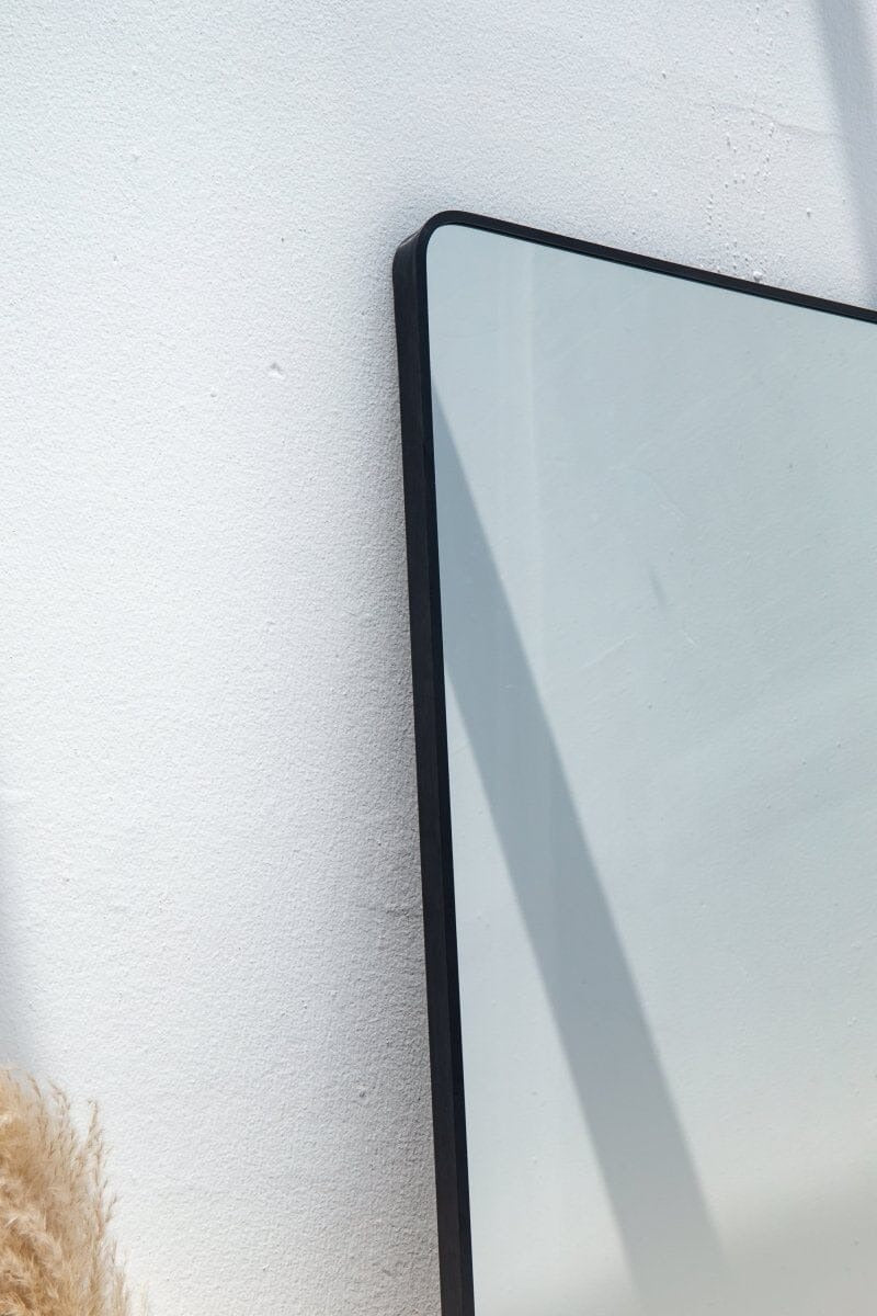 Grand miroir rectangulaire noir à coins arrondis, style minimaliste et contemporain.