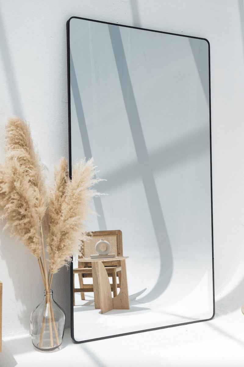 Miroir mural élégant avec cadre noir mat – décoration moderne pour salon ou entrée.