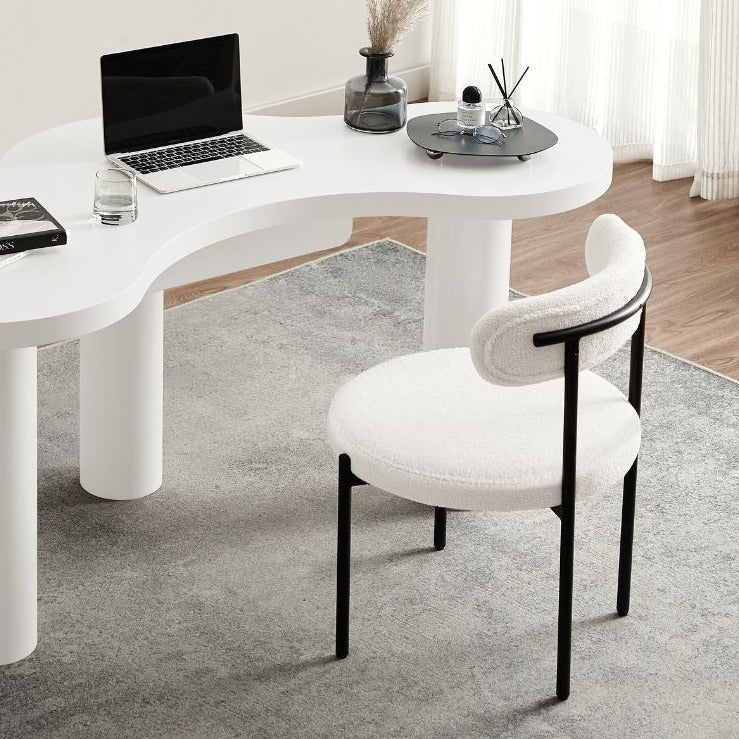 Profil de la chaise en bouclette avec dossier incurvé et assise rembourrée, structure stable et design contemporain.