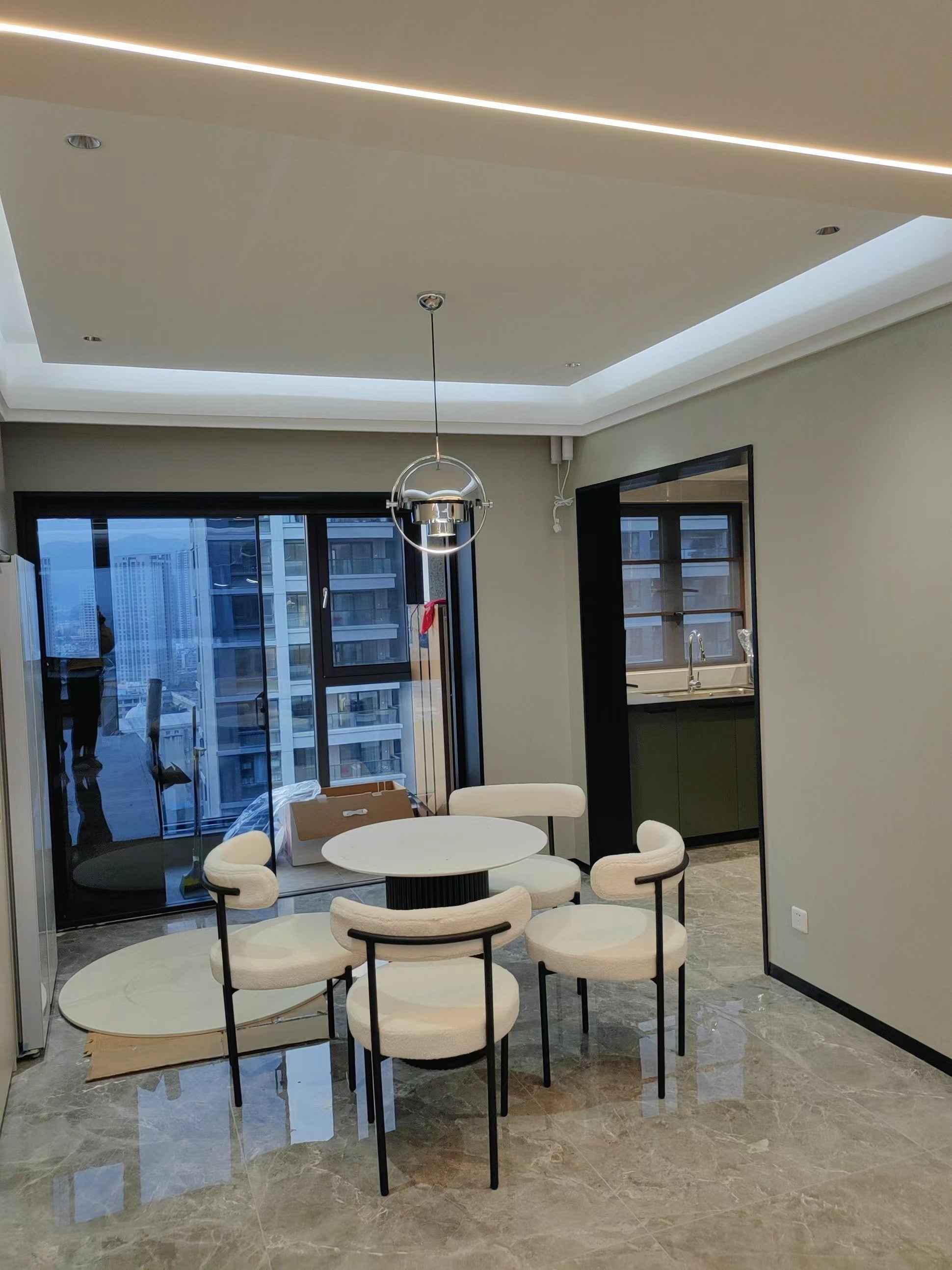 Salle à manger moderne avec table ronde et chaises dans une pièce bien éclairée.